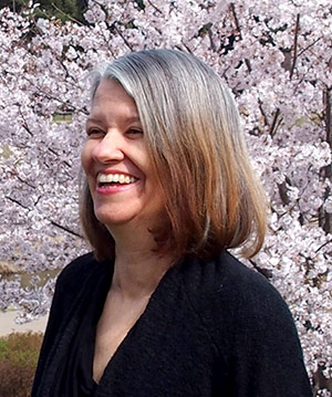Photo of Colleen Keating in front of cherry blossoms